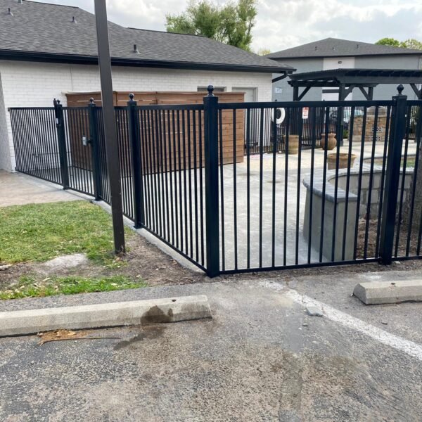 Black metal fence installed around a residential property with secure gate access in Houston, TX